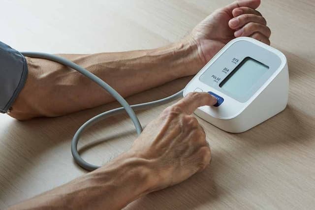 Man using home blood pressure monitor