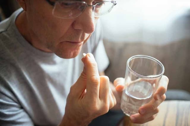 Man taking a pill with water
