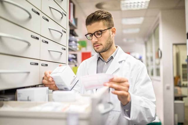 Pharmacist selecting medicine.