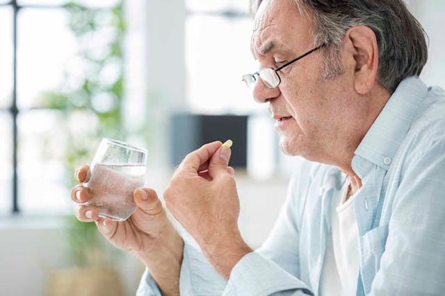 Man taking pill with water